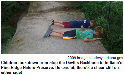 Children look down from atop the Devil’s Backbone in Indiana’s Pine Ridge Nature Preserve. Be careful; there’s a sheer cliff on either side! 2009 image courtesy indiana.gov.